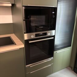 Stilvoller Küchenbereich mit grünem Design und Ofen,Mikrowelle Grün gestalteter Küchenbereich mit Ofen und Mikrowelle, die eine zeitgemäße und funktionale Atmosphäre schaffen