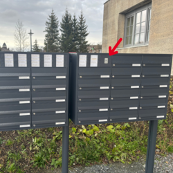 Briefkästen mit rotem Pfeil: Hervorgehobener Briefkasten im Fokus Bild von zwei schwarzen Briefkästen, mit einem roten Pfeil, der auf einen Briefkasten zeigt